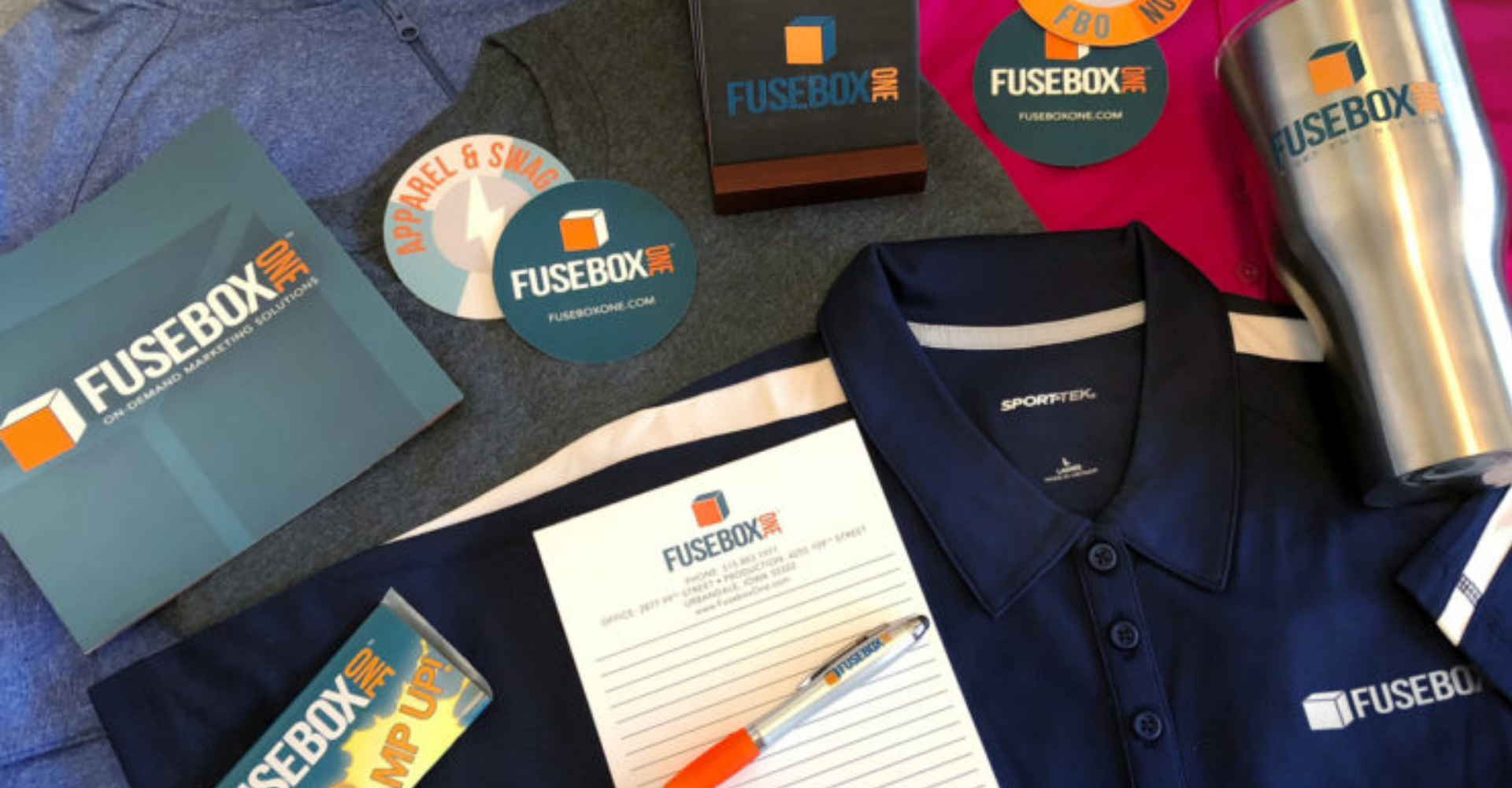FuseBox One Polo, Pen, and Coasters on a table.